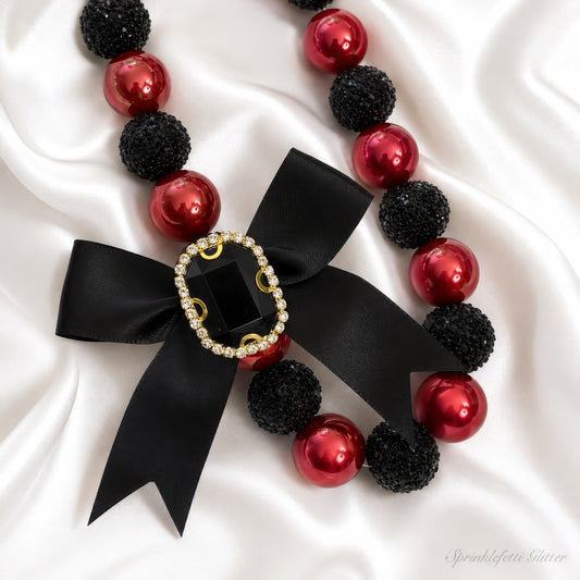 Alternate view of the Crimson Heiress Necklace with crimson pearls, black sparkle beads, and jeweled bow on pure white background