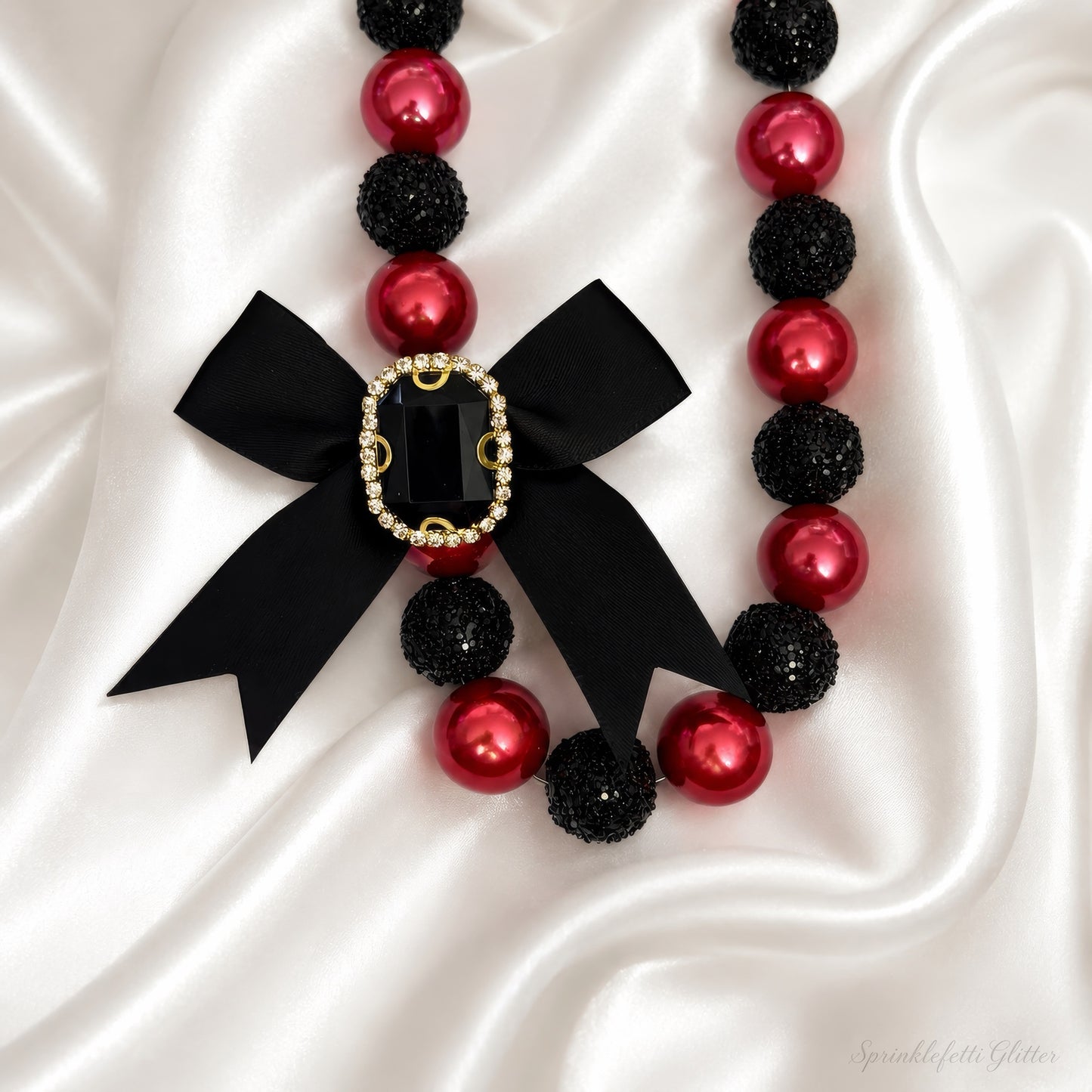 Crimson Heiress Necklace with crimson pearls, black sparkle beads, and jeweled black bow