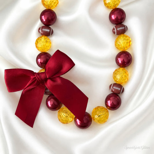Game Day Spirit Necklace with customizable football team colors and bow on white background