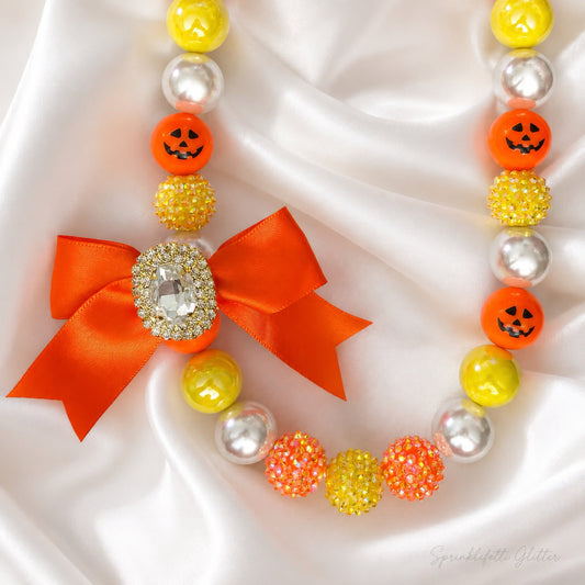 Pumpkin Confection Couture Necklace in orange, yellow, and ivory with jeweled bow on white background