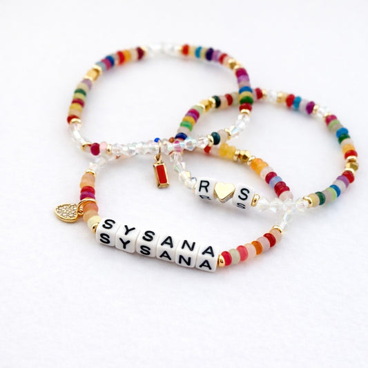Three colorful personalized Rainbow Confetti bracelets with gold charms