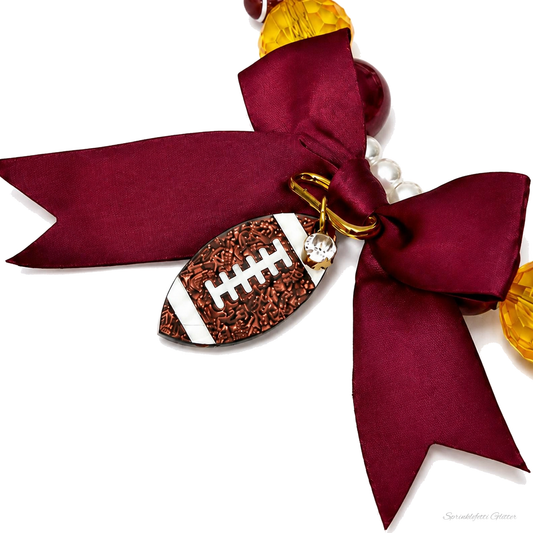 Game Day Football Necklace macro detail showing football beads, crystals and satin bow on pure white background