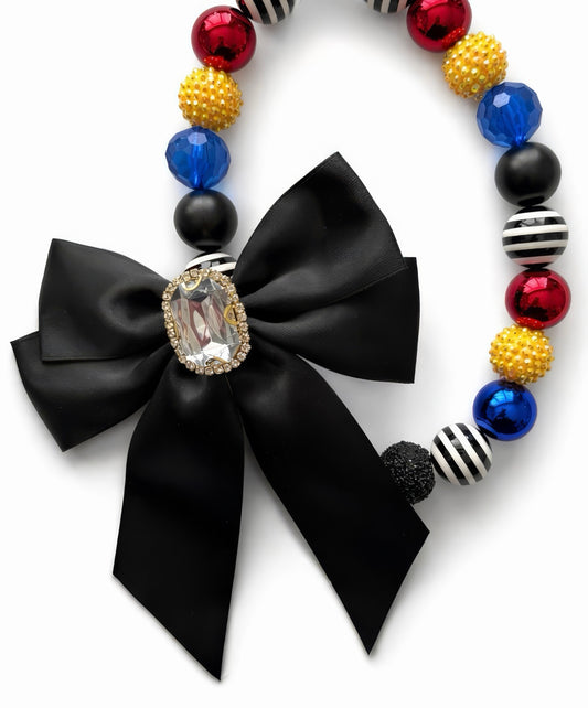 Midnight Heiress statement necklace with black satin bow, Austrian crystal centerpiece, red, blue, gold and striped beads