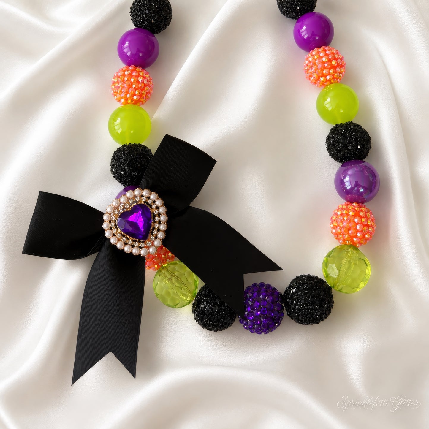 Spellbound Heiress Necklace in purple, orange, lime, and black with heart jewel