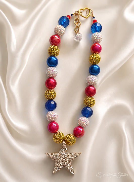 Star Spangled Heiress statement necklace with red, blue, white and gold beads and crystal-covered star pendant